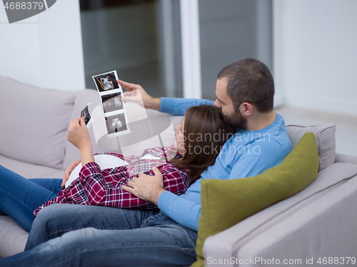 Image of pregnant couple looking baby\'s ultrasound