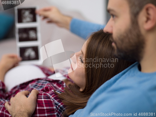 Image of pregnant couple looking baby\'s ultrasound