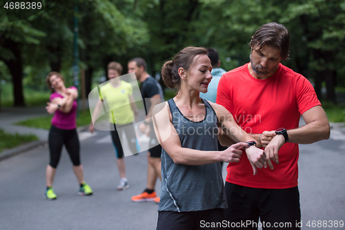 Image of sporty couple using smart watches