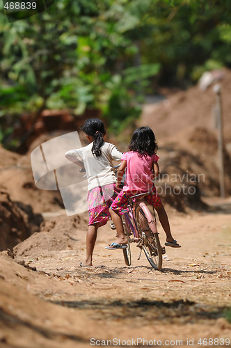 Image of two cambodian kids on one bicycle