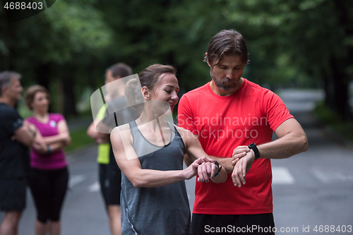 Image of sporty couple using smart watches