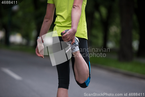 Image of female runner warming up and stretching before morning training