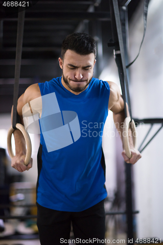 Image of man working out pull ups with gymnastic rings