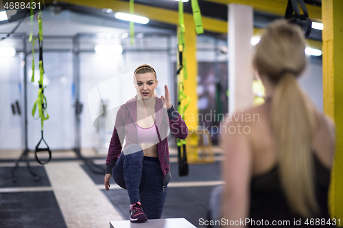 Image of athletes working out  jumping on fit box