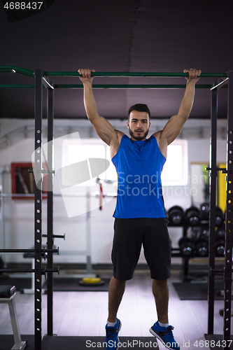 Image of man doing pull ups on the horizontal bar