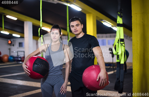 Image of young athletes couple working out with medical ball