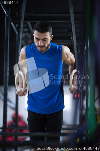 Image of man working out pull ups with gymnastic rings