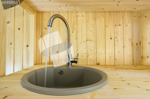 Image of Natural wood kitchen from faucet text water close-up