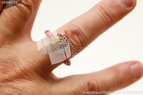 Image of unpretentious finger ring made of recycled materials on the fing