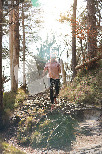 Image of Active sporty woman running in autumn fall forest. Female runner training outdoor. Healthy lifestyle image of young caucasian woman jogging outside.