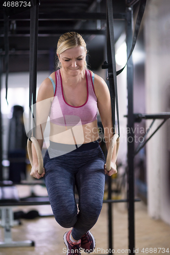 Image of woman working out pull ups with gymnastic rings