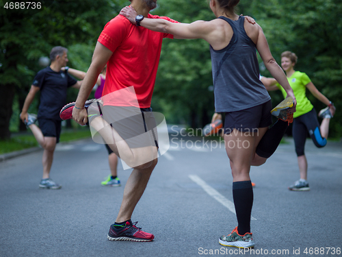 Image of runners team warming up and stretching before morning training