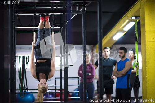 Image of woman working out with personal trainer on gymnastic rings