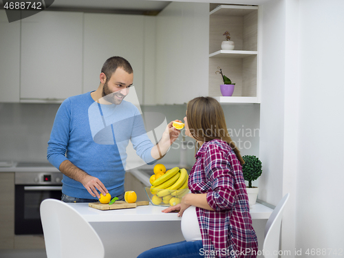 Image of couple cooking food fruit lemon juice at kitchen