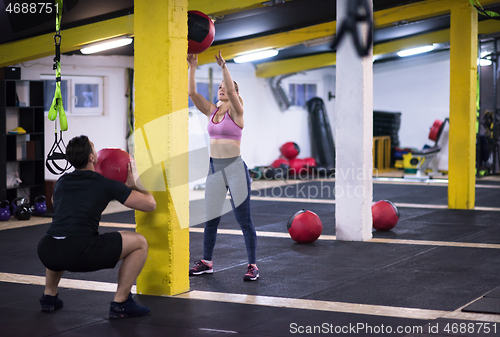 Image of young athletes couple working out with medical ball