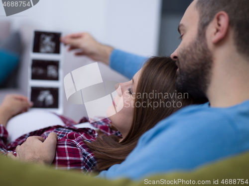 Image of pregnant couple looking baby\'s ultrasound