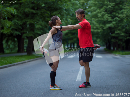 Image of runners team warming up and stretching before morning training