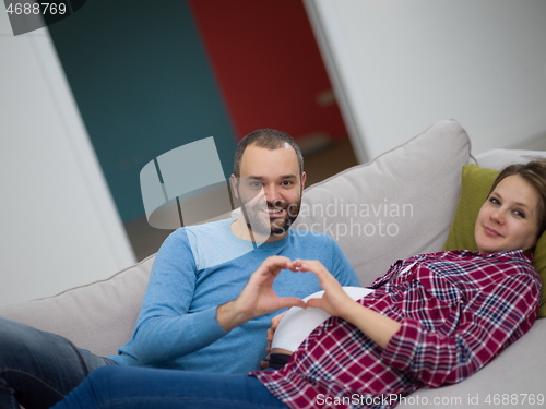 Image of man and pregnant woman showing heart sign