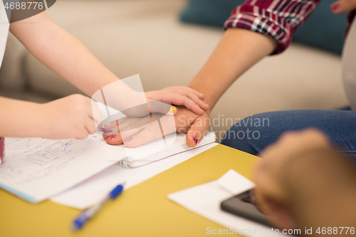 Image of daughter painting nails to her pregnant mom