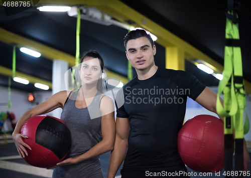 Image of young athletes couple working out with medical ball