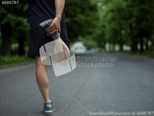 Image of male runner warming up and stretching before morning training