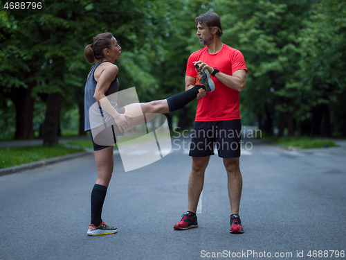 Image of runners team warming up and stretching before morning training