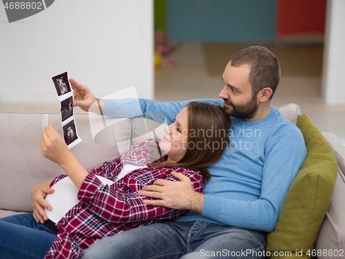 Image of pregnant couple looking baby\'s ultrasound