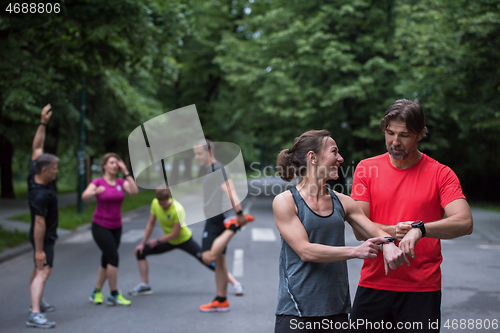 Image of sporty couple using smart watches