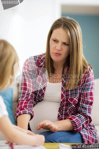 Image of daughter painting nails to her pregnant mom