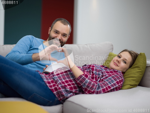 Image of man and pregnant woman showing heart sign