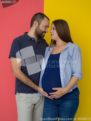 Image of pregnant couple  isolated over colorful background