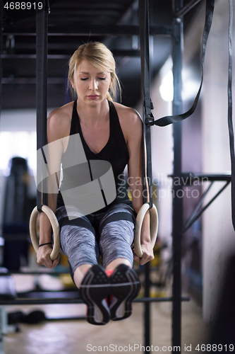 Image of woman working out pull ups with gymnastic rings