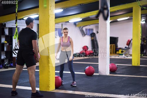 Image of young athletes couple working out with medical ball