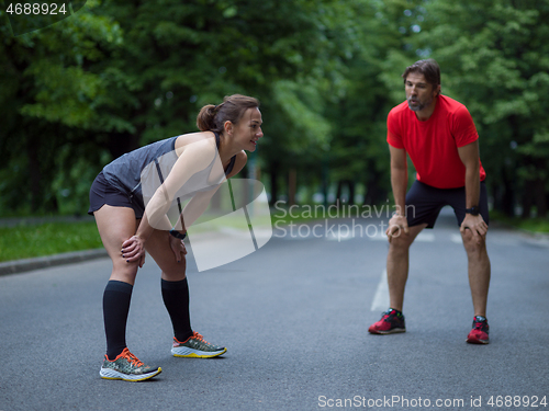 Image of runners team warming up and stretching before morning training