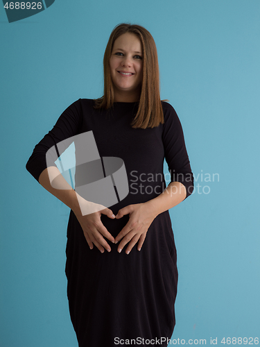 Image of Portrait of pregnant woman over blue background