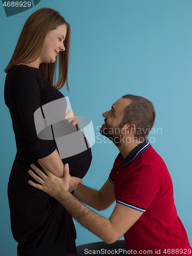 Image of pregnant couple  isolated over blue background