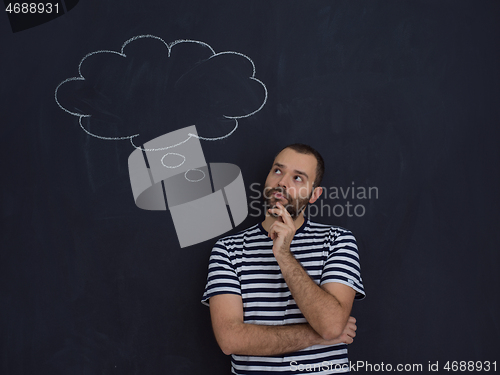 Image of young future father thinking in front of black chalkboard