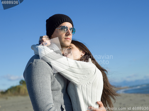 Image of Loving young couple on a beach at autumn sunny day