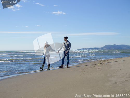 Image of Loving young couple on a beach at autumn sunny day