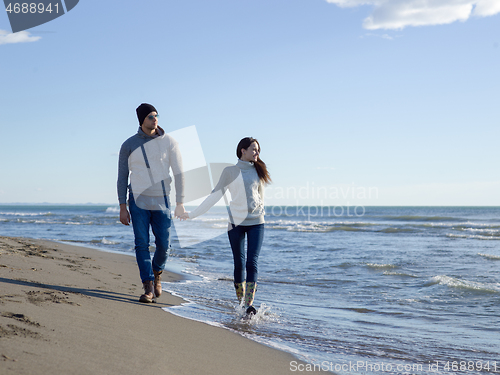 Image of Loving young couple on a beach at autumn sunny day