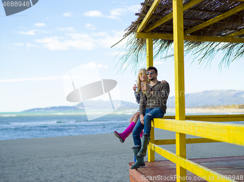 Image of young couple drinking beer together at the beach