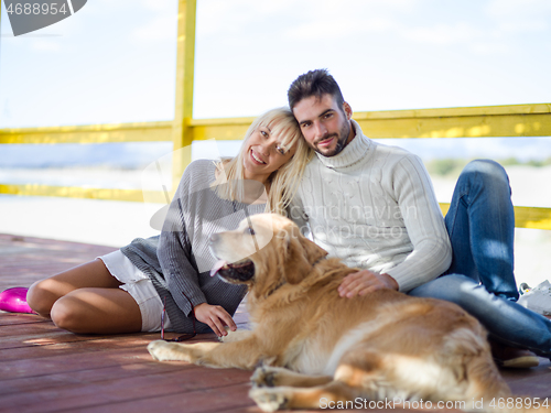 Image of Couple with dog enjoying time on beach