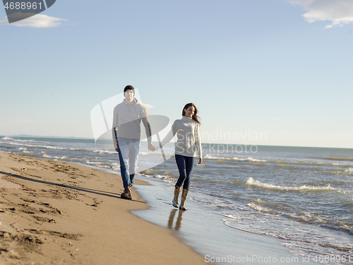 Image of Loving young couple on a beach at autumn sunny day