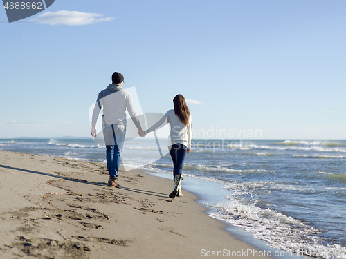 Image of Loving young couple on a beach at autumn sunny day