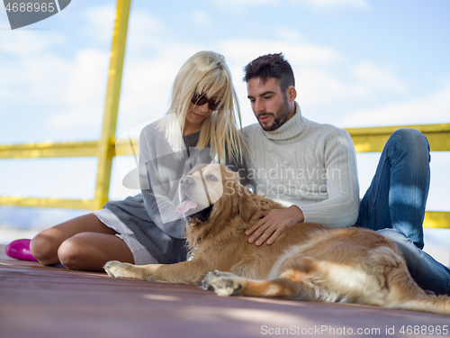 Image of Couple with dog enjoying time on beach