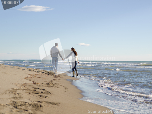 Image of Loving young couple on a beach at autumn sunny day