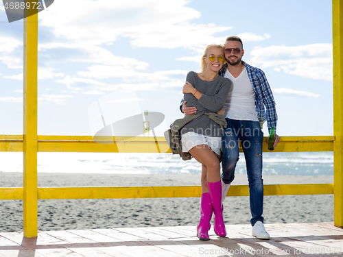 Image of young couple drinking beer together at the beach