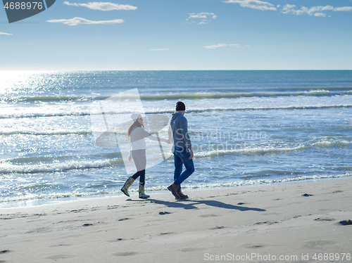 Image of Loving young couple on a beach at autumn sunny day