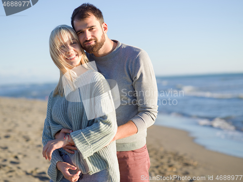 Image of Loving young couple on a beach at autumn sunny day