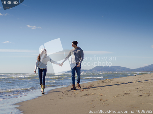 Image of Loving young couple on a beach at autumn sunny day